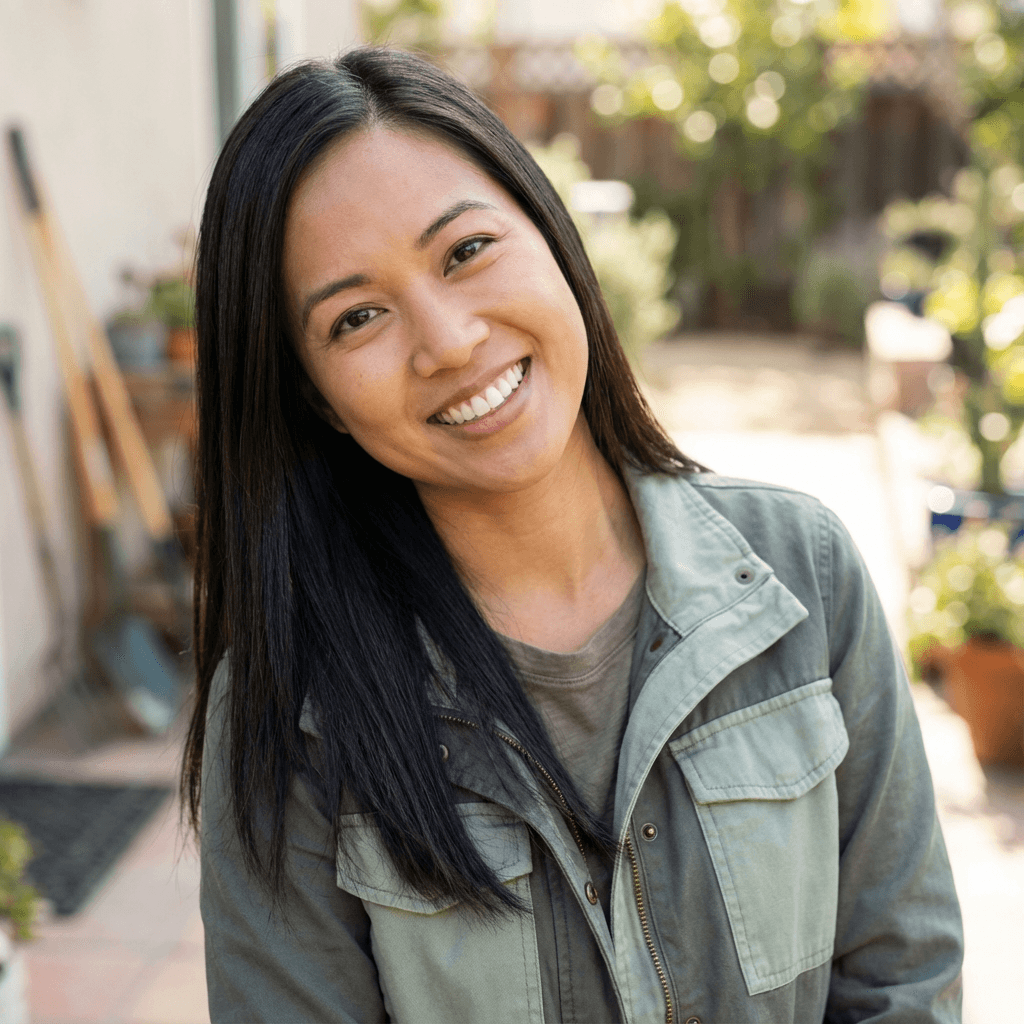 Emily Nguyen smiling at a plant-filled storefront